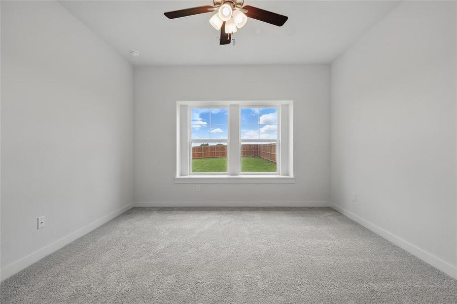 Unfurnished room featuring carpet floors, ceiling fan, and baseboards Unfurnished room featuring carpet floors, ceiling fan, and baseboards