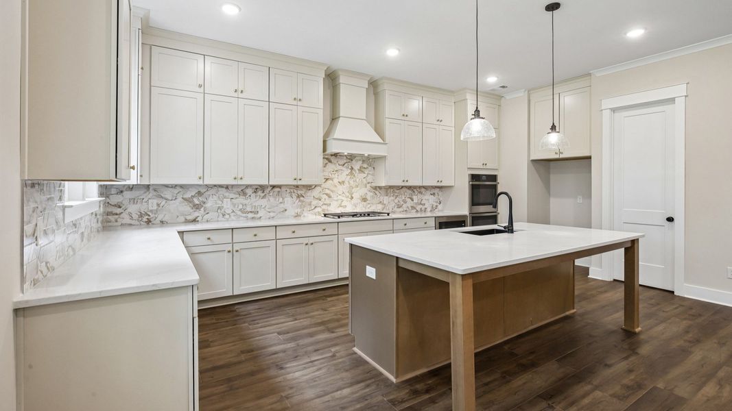 Kitchen with quartz countertops, tile backsplash, and pendant lighting Kitchen with quartz countertops, tile backsplash, and pendant lighting