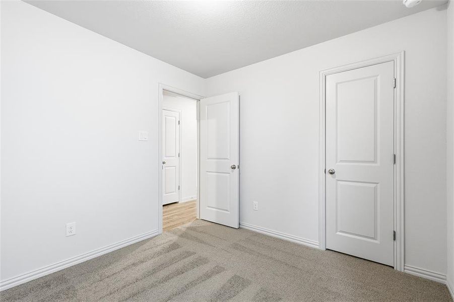 Unfurnished bedroom with carpet flooring and baseboards