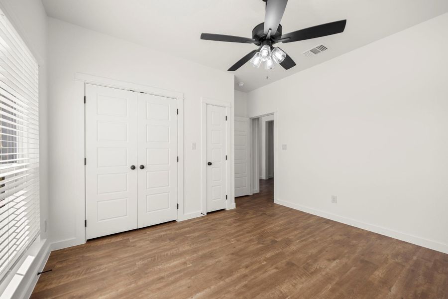 Streamlined, modern design defines this well-appointed bedroom with a contemporary ceiling fan.