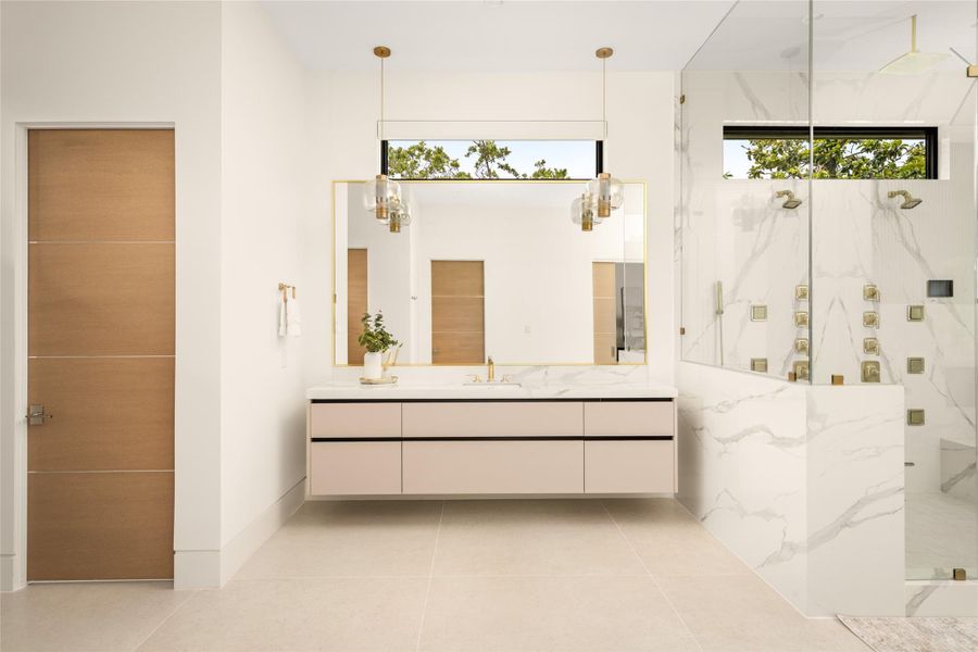 Refined primary bath vanity with custom cabinetry, statement lighting, and a clean, modern design.