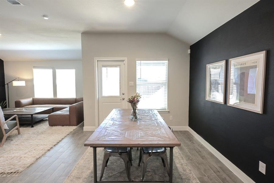 Dining room with lofted ceiling, wood-look tile floors