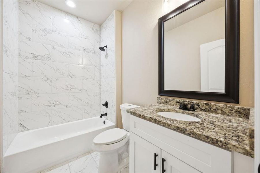 Full bath featuring shower / washtub combination, vanity, light marble finish floors, and recessed lighting Full bath featuring shower / washtub combination, vanity, light marble finish floors, and recessed lighting