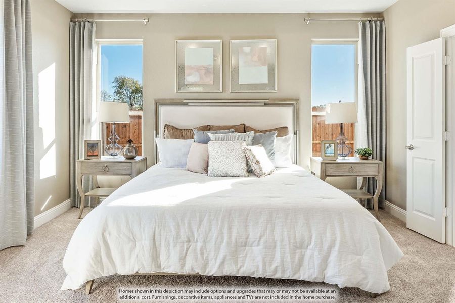 Bedroom with king-size bed, neutral tones, two windows with gray curtains, and carpeted floors