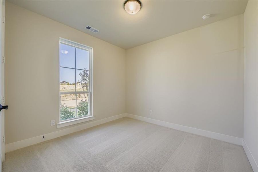 Empty room featuring light colored carpet and baseboards Empty room featuring light colored carpet and baseboards