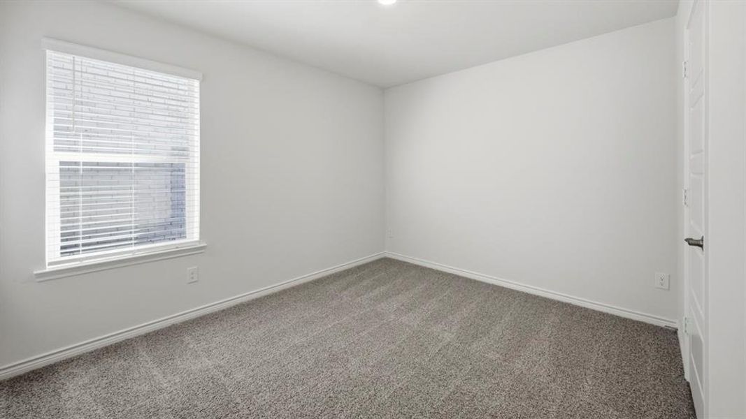 Carpeted spare room featuring baseboards