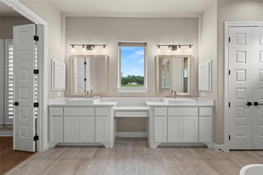 Dual vanities with pristine white countertops provide ample space in this well-appointed bathroom. Dual vanities with pristine white countertops provide ample space in this well-appointed bathroom.