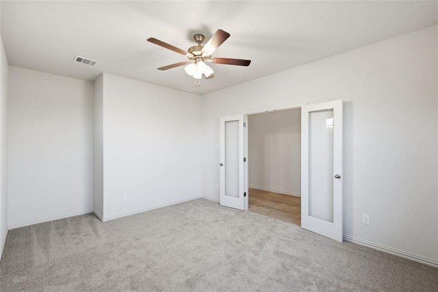 Unfurnished room with light carpet and a ceiling fan