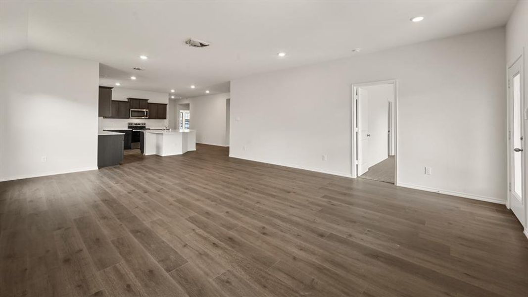 Open concept living area featuring wood-finish flooring and recessed lighting Open concept living area featuring wood-finish flooring and recessed lighting