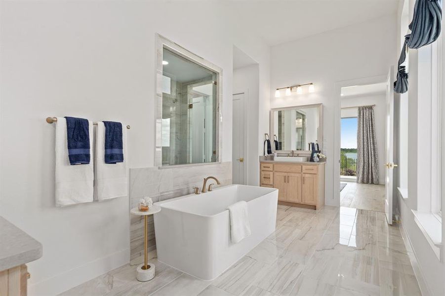 Bathroom with vanity, a freestanding bath, light marble finish flooring, and a shower stall Bathroom with vanity, a freestanding bath, light marble finish flooring, and a shower stall