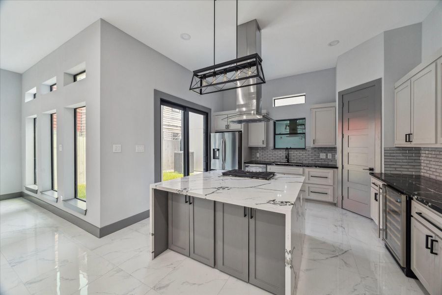 Walls of windows connect the kitchen and living area, creating an easy flow for both dining and entertaining. A spacious island anchors the open layout, while clean finishes and modern details bring style and function together. Walls of windows connect the kitchen and living area, creating an easy flow for both dining and entertaining. A spacious island anchors the open layout, while clean finishes and modern details bring style and function together.