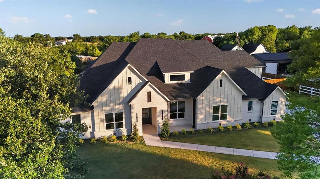 Contemporary farmhouse architecture featuring light-colored brick and vertical siding accents Contemporary farmhouse architecture featuring light-colored brick and vertical siding accents