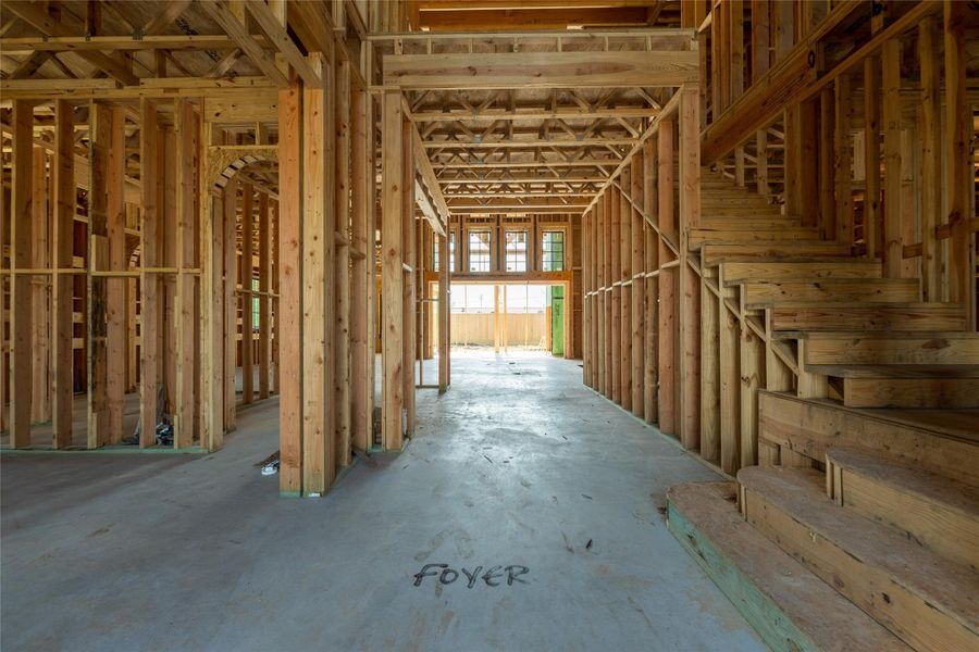 Even in its earliest form, the foyer reveals a strong sense of arrival. The alignment of framing, natural light ahead, and the staircase rising alongside create a moment that will transition seamlessly into a warm, curated entry experience.