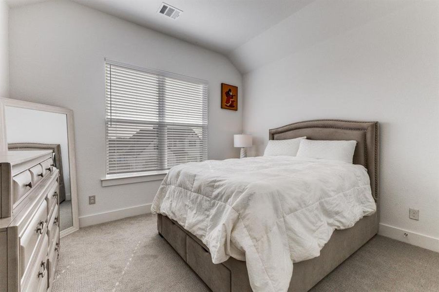 Bedroom featuring lofted ceiling and light colored carpet
