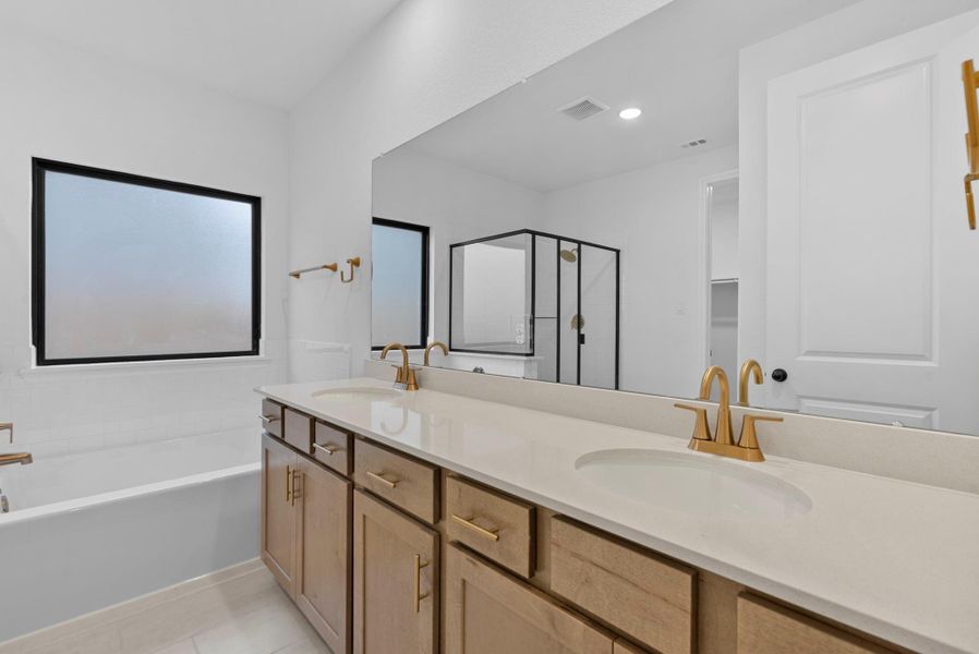 Just off the primary bedroom, the spa-like bath features a double vanity with warm natural finishes, inviting calm, relaxing mornings.