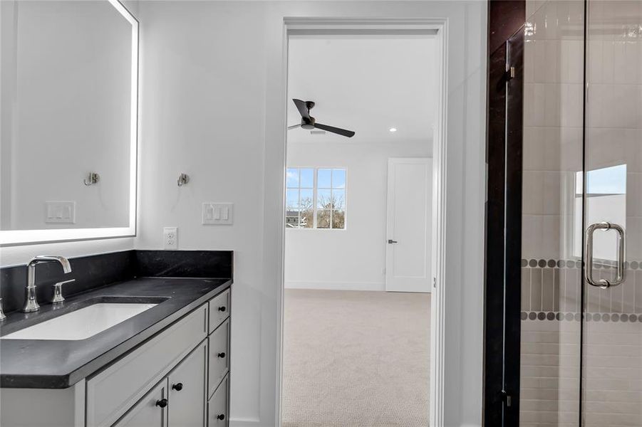 Bathroom featuring vanity, a stall shower, light carpet, ceiling fan, and recessed lighting Bathroom featuring vanity, a stall shower, light carpet, ceiling fan, and recessed lighting