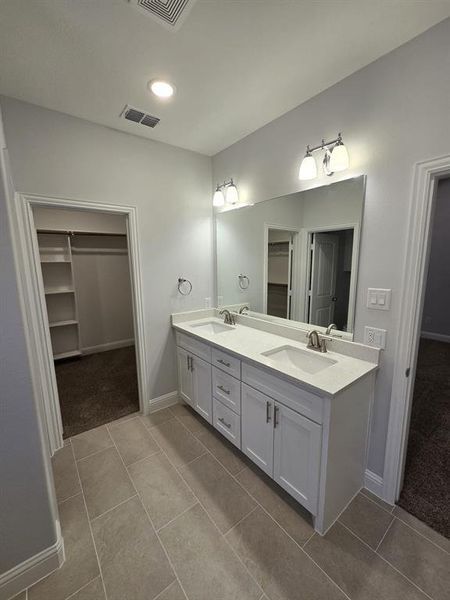 Bathroom with double sink vanity and tile patterned flooring