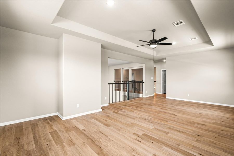Spacious open-concept living area that will become the hub of your home. This central space features beautiful hardwood floors, a modern ceiling fan, high ceilings, and ample natural light, perfect for entertaining or relaxing.