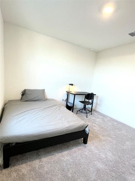 Bedroom featuring light carpet and baseboards