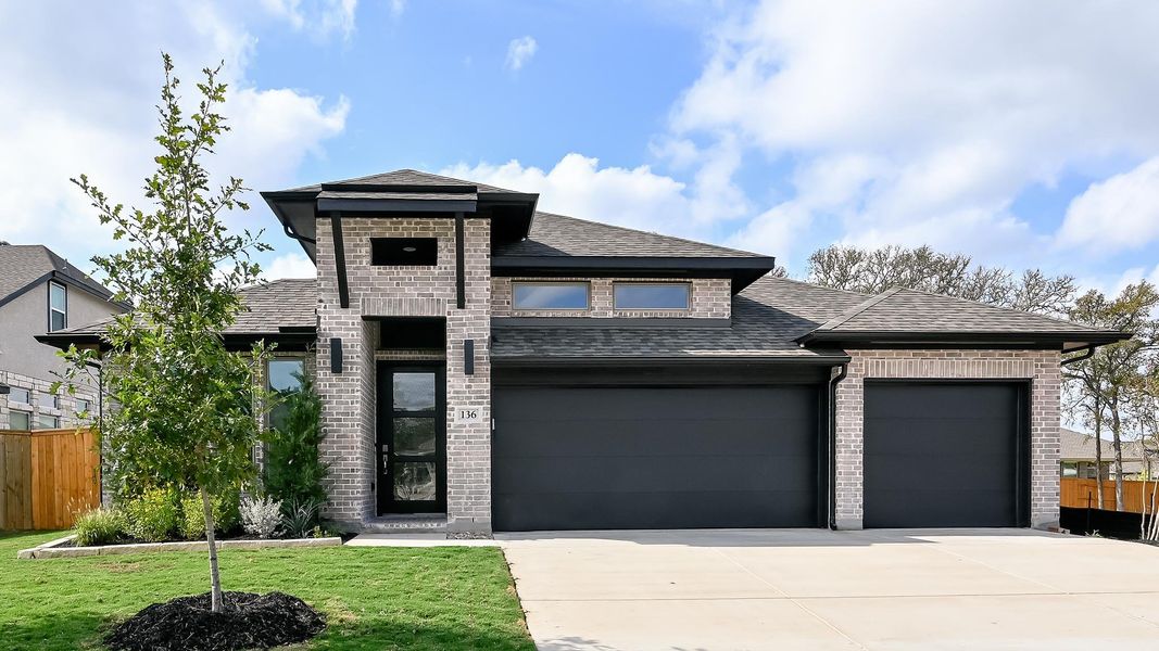 View of front of home with roof with shingles, brick siding, an attached garage, and concrete driveway View of front of home with roof with shingles, brick siding, an attached garage, and concrete driveway