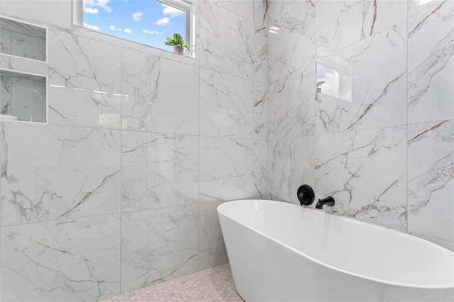 Freestanding soaking tub with matte black fixtures