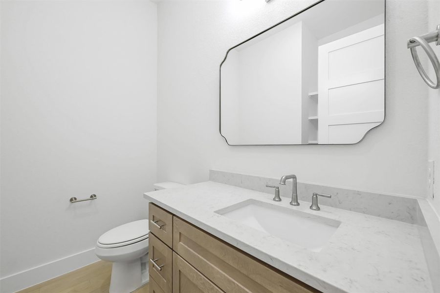 Half bathroom with vanity and wood finished floors