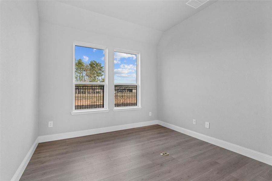 This handsome home office features laminate flooring, large windows, high sloped ceilings, and custom paint!