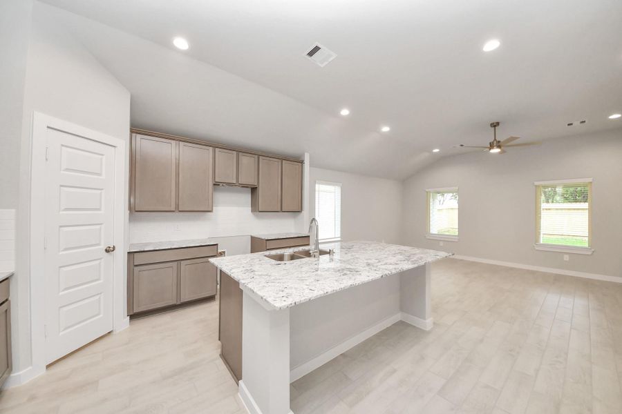 This kitchen is by far any chef’s dream! This spacious kitchen features high ceilings, light stained wood cabinets, granite countertop, SS appliances, modern tile backsplash, recessed lighting, extended counter space, granite kitchen island with double sink, and space for breakfast bar, and a walk-in pantry all overlooking your huge family room. Sample photo of completed home with similar floor plan. Actual colors and selections may vary.