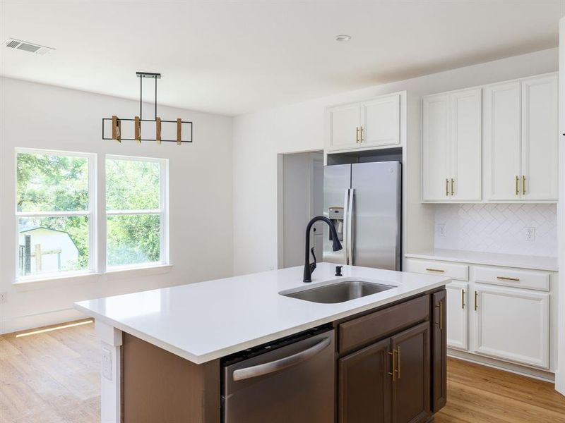 Kitchen looks out to backyard via large windows.