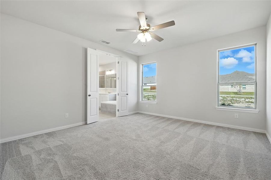 Unfurnished bedroom with light carpet, a ceiling fan, and ensuite bathroom Unfurnished bedroom with light carpet, a ceiling fan, and ensuite bathroom