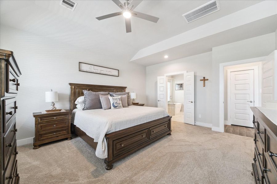 Serene primary bedroom featuring soft gray tones, plush carpet, matching wood furnishings, and a private en-suite bath. Serene primary bedroom featuring soft gray tones, plush carpet, matching wood furnishings, and a private en-suite bath.