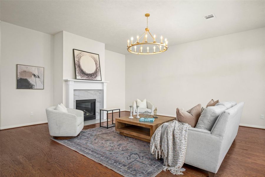 The spacious living room offers flexibility for multiple conversation areas drenched with abundant natural light by day and lit by the chandelier and gas-log fireplace at night. The spacious living room offers flexibility for multiple conversation areas drenched with abundant natural light by day and lit by the chandelier and gas-log fireplace at night.