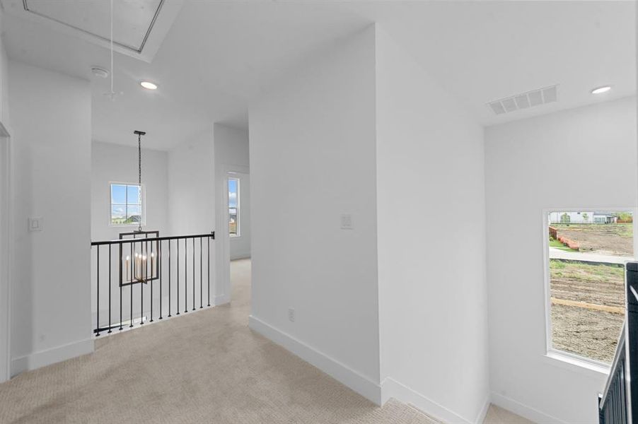 Corridor featuring light carpet, attic access, visible vents, and recessed lighting