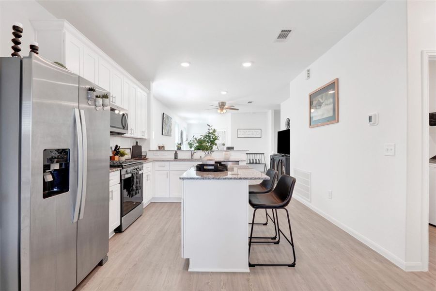 Fall in love with a modern chef’s kitchen featuring stainless-steel appliances, sleek cabinetry, ample counter space, and a large breakfast bar, creating a perfect balance of beauty and functionality.