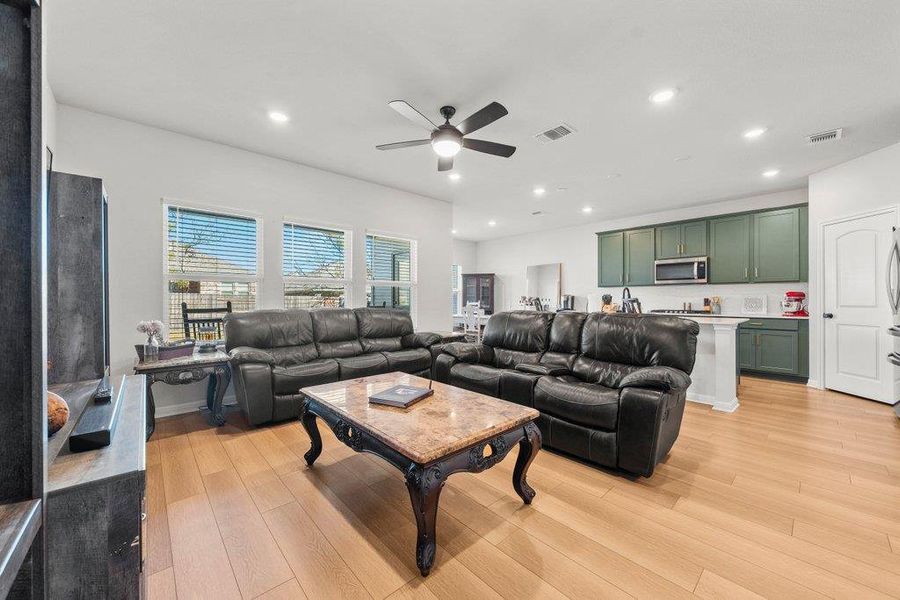 Living room with light wood-style floors, recessed lighting, and ceiling fan