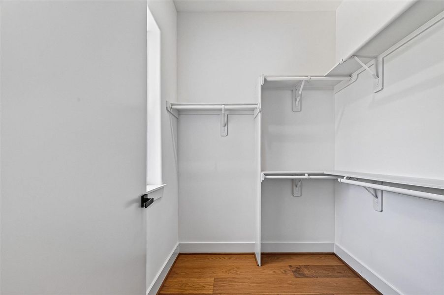 Primary bedroom walk-in closet with shelving. Primary bedroom walk-in closet with shelving.