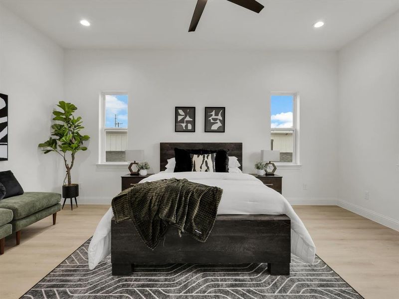 Bedroom featuring ceiling fan, light hardwood / wood-style flooring, and multiple windows