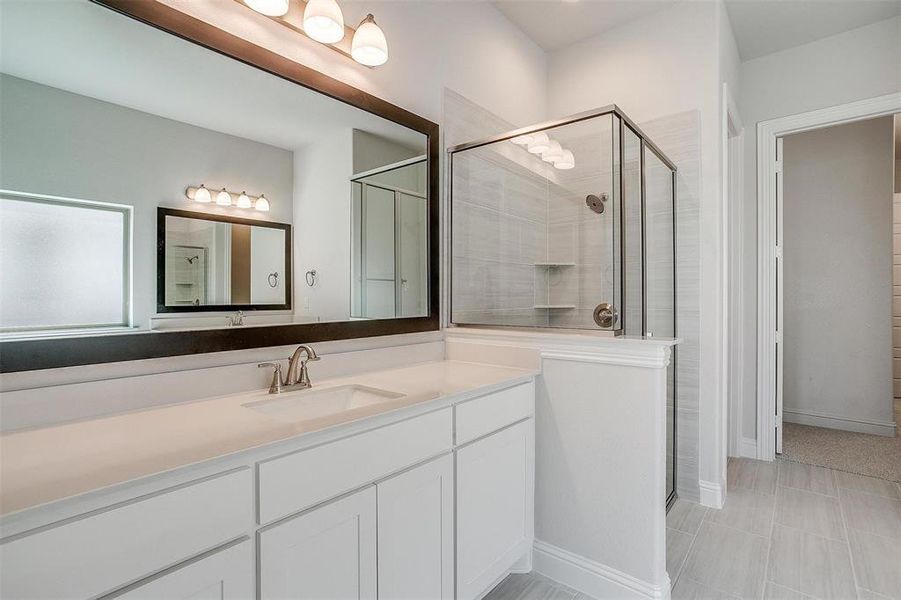 Bathroom with vanity and a shower with door