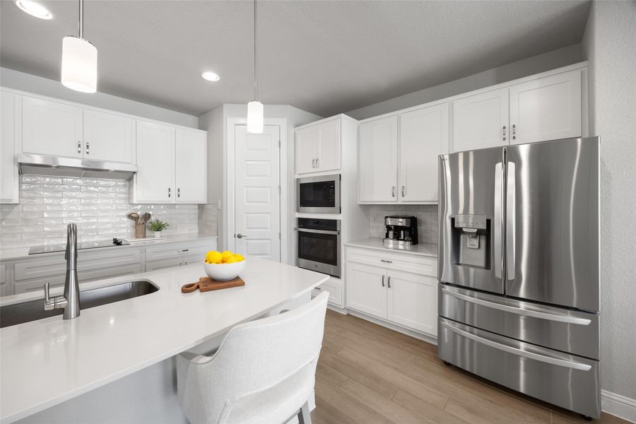 Kitchen featuring stainless steel appliances, decorative backsplash, hanging light fixtures, and recessed lighting