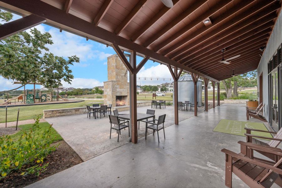 View of patio / terrace featuring outdoor dining space and an outdoor stone fireplace View of patio / terrace featuring outdoor dining space and an outdoor stone fireplace