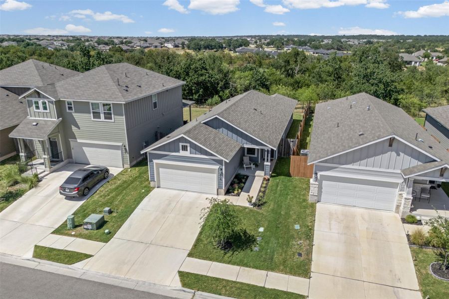 Neat suburban streetscape highlights matching asphalt shingle roofs and concrete driveways.