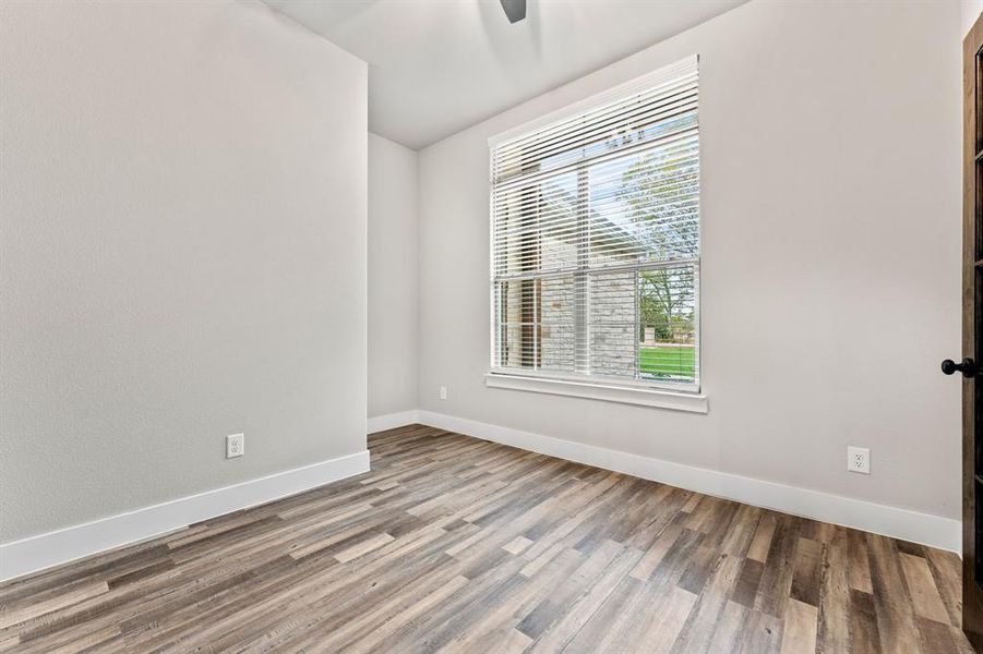 Empty room with ceiling fan, wood-type flooring, and plenty of natural light