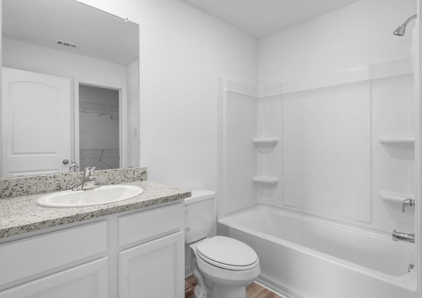 Granite countertops and white cabinets in the master bathroom