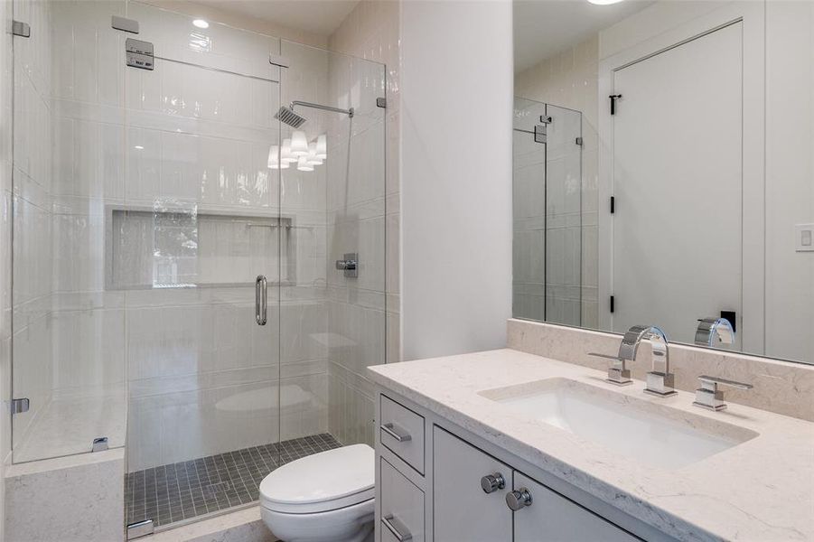 Bathroom featuring a shower stall and vanity Bathroom featuring a shower stall and vanity