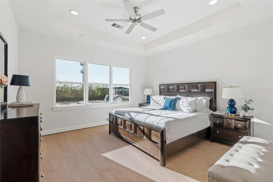 Spacious primary suite with a tray ceiling, wide rear window, and enough room for a king setup without the space feeling crowded. Spacious primary suite with a tray ceiling, wide rear window, and enough room for a king setup without the space feeling crowded.