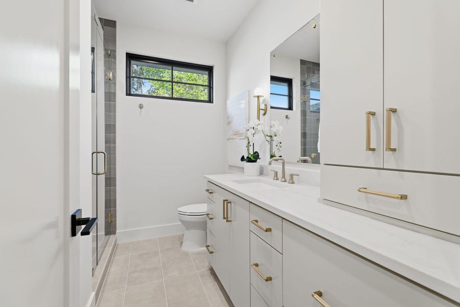 Full bathroom featuring light tile patterned floors, vanity, and a stall shower