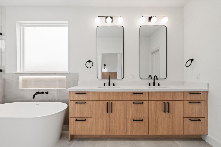 Stunning double vanity with modern wood cabinetry, black fixtures, and sleek lighting.