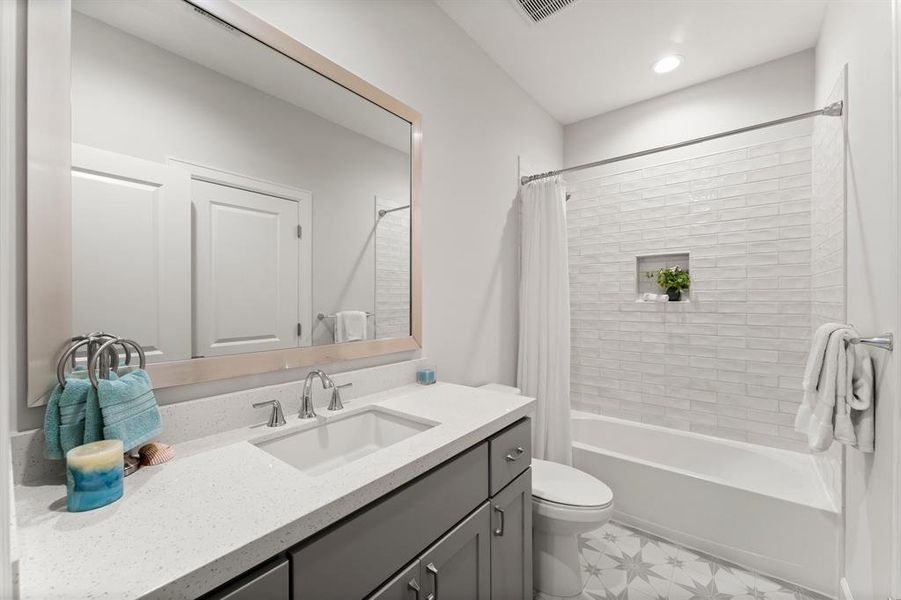 This full bath features an extended counter space, extra cabinet storage, custom flooring and upgraded subway tile in the shower.