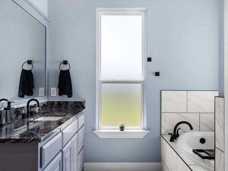 Bathroom with plenty of natural light, vanity, and a bath Bathroom with plenty of natural light, vanity, and a bath