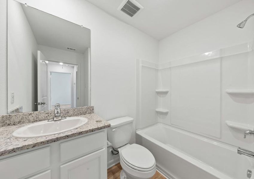 A secondary bathroom with granite countertops